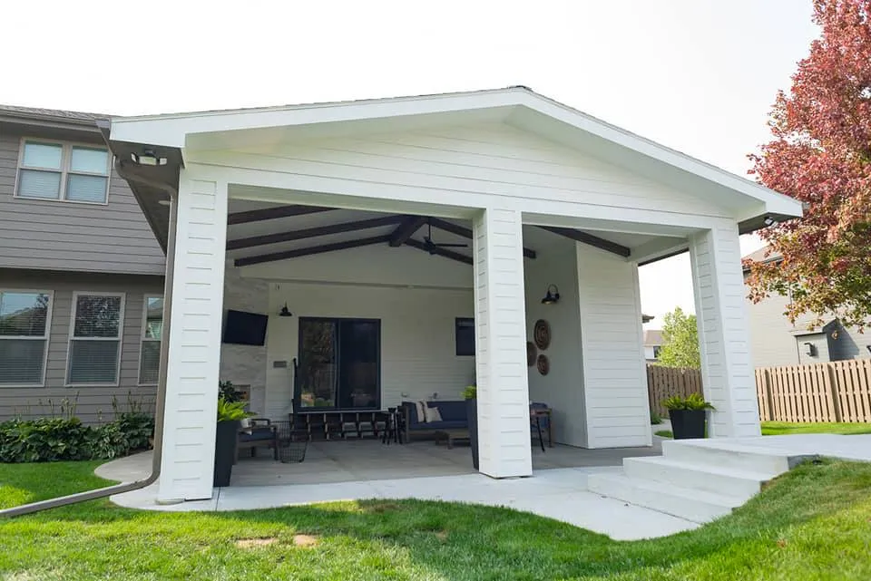 Covered outdoor living space with patio furniture by Banded Construction